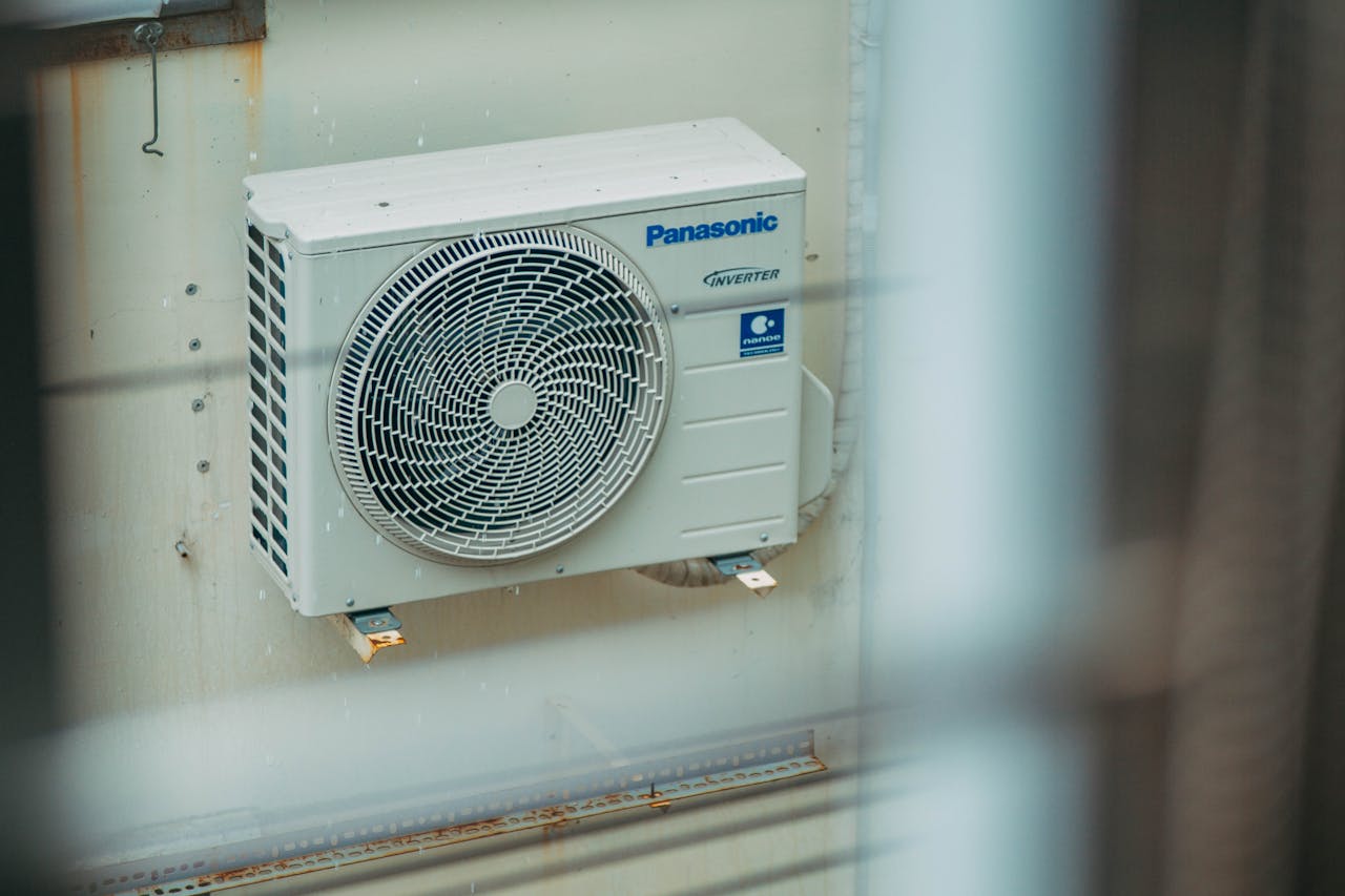 about-01 Air conditioner unit mounted outdoors on a building wall, showcasing modern HVAC technology.